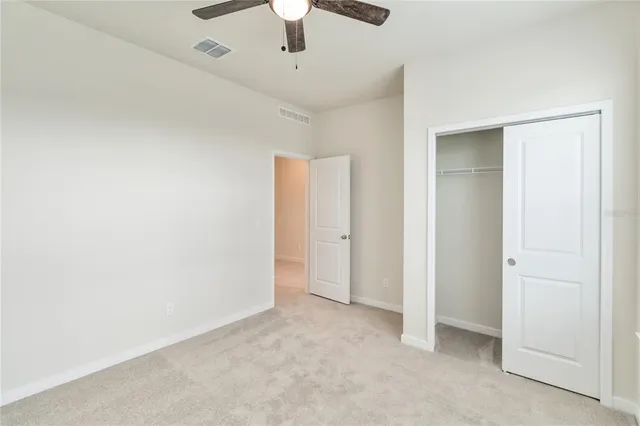 an empty room with chandelier fan