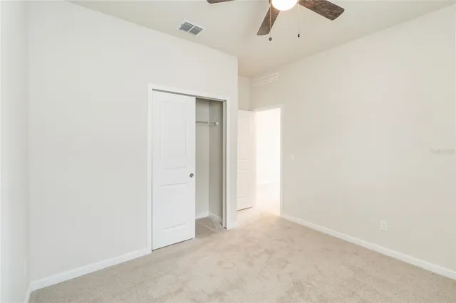 an empty room with a ceiling fan and a window