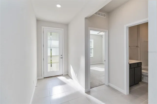a view of an empty room with closet and a window