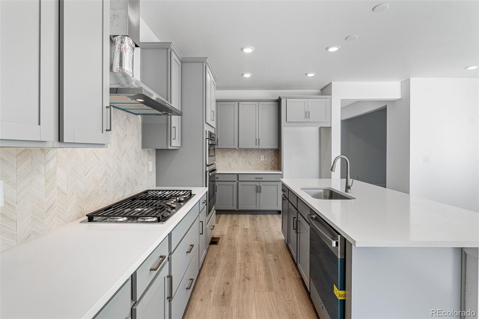 23936 River Front Drive Aurora, CO 80019 - Photo 11 of 46 a kitchen with kitchen island stainless steel appliances a sink stove and cabinets