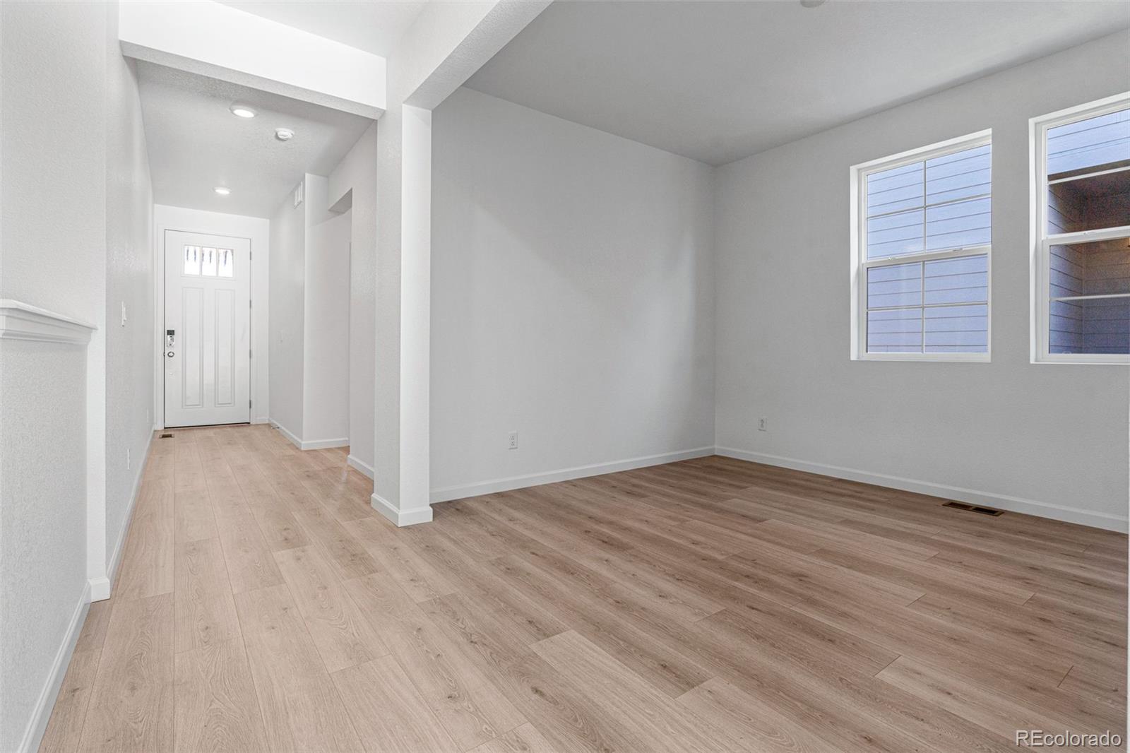 23936 River Front Drive Aurora, CO 80019 - Photo 14 of 46 an empty room with wooden floor and windows
