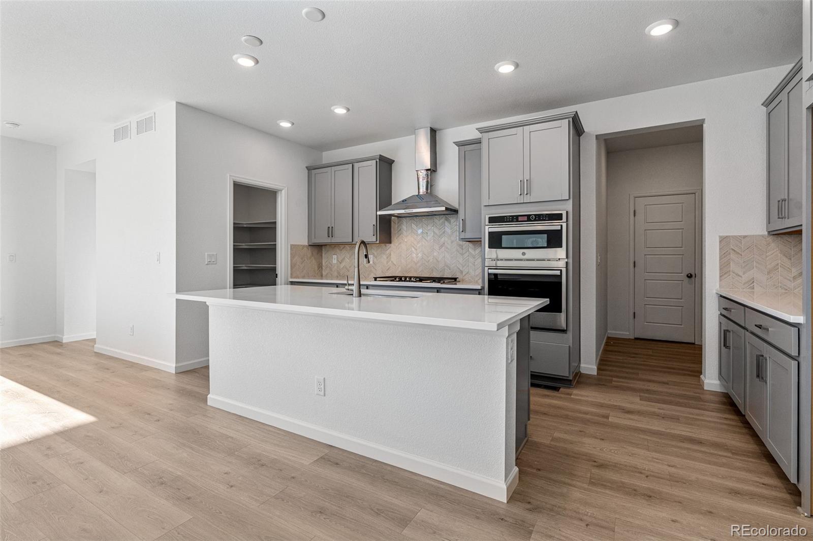 23936 River Front Drive Aurora, CO 80019 - Photo 9 of 46 a kitchen with kitchen island a counter top space a sink stainless steel appliances and cabinets