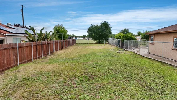 a view of a backyard with wooden fence