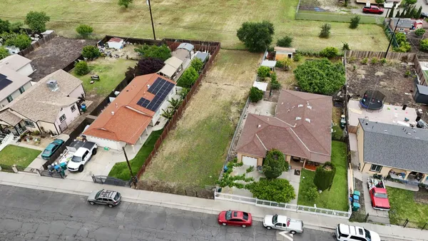 an aerial view of a house with a garden and parking space