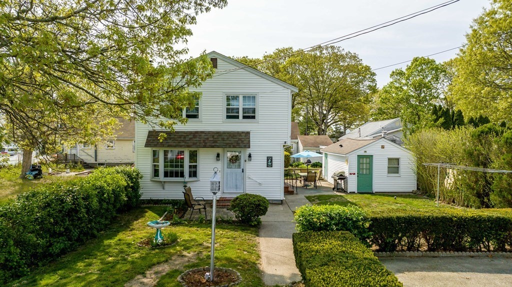 a front view of a house with a garden and plants