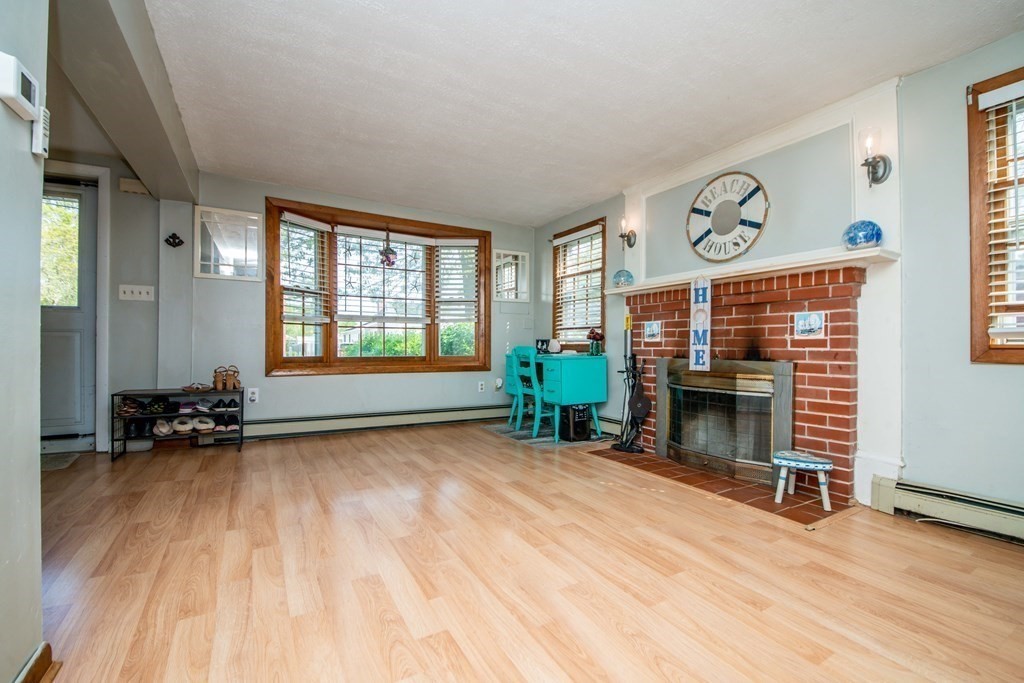 9 Grant Street Wareham, MA 02571 - Photo 6 of 18 a view of an empty room with a fireplace and a window