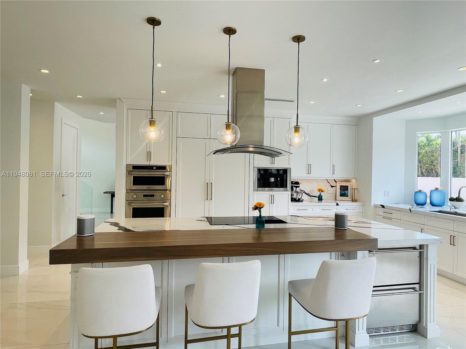 7233 Southwest 122 Place Miami, FL 33183 - Photo 13 of 58 a kitchen with stainless steel appliances kitchen island a table chairs sink and microwave
