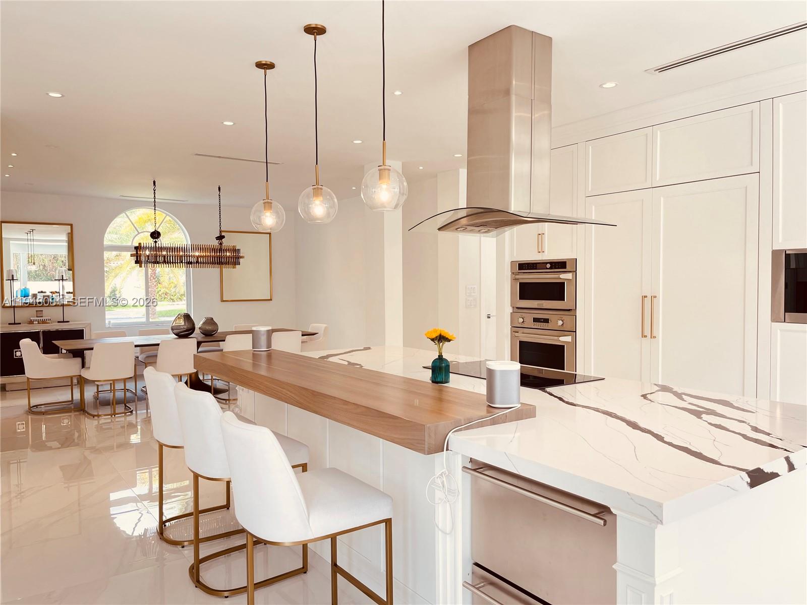 7233 Southwest 122 Place Miami, FL 33183 - Photo 14 of 58 a kitchen with stainless steel appliances kitchen island granite countertop a table chairs and a view of living room