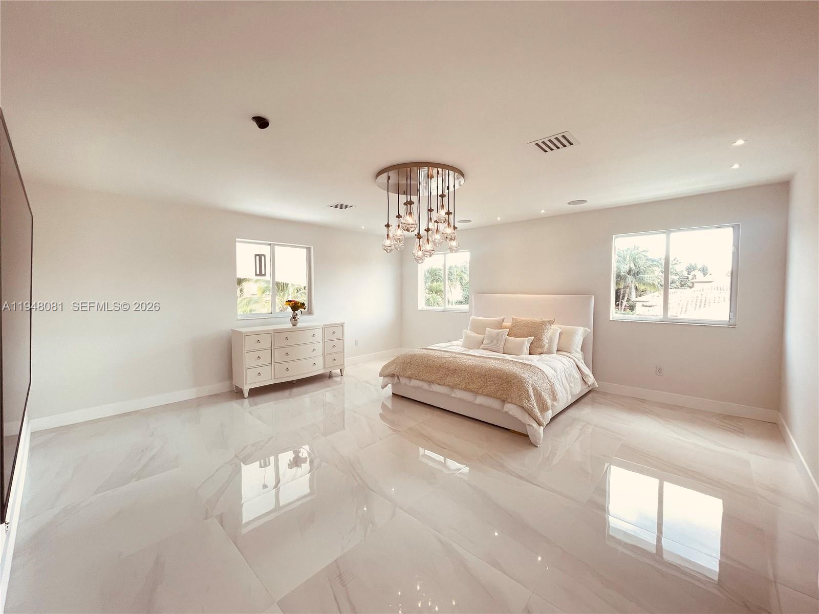 7233 Southwest 122 Place Miami, FL 33183 - Photo 46 of 78 a spacious bedroom with a bed and a chandelier