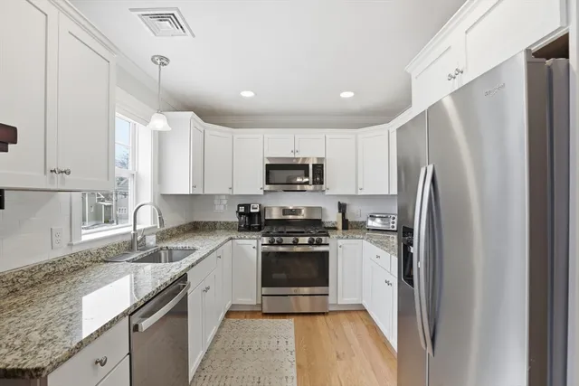 a kitchen with stainless steel appliances granite countertop a refrigerator sink and stove