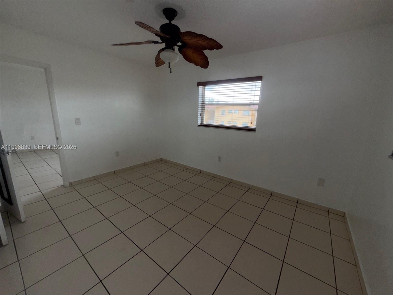 120 Royal Palm Road, Unit 301 Hialeah Gardens, FL 33016 - Photo 18 of 32 an empty room with a ceiling fan and window