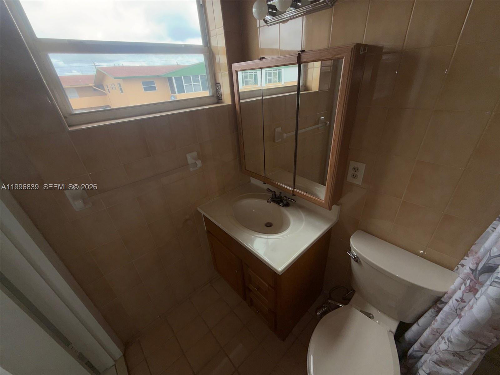 120 Royal Palm Road, Unit 301 Hialeah Gardens, FL 33016 - Photo 22 of 32 a bathroom with a sink toilet and vanity