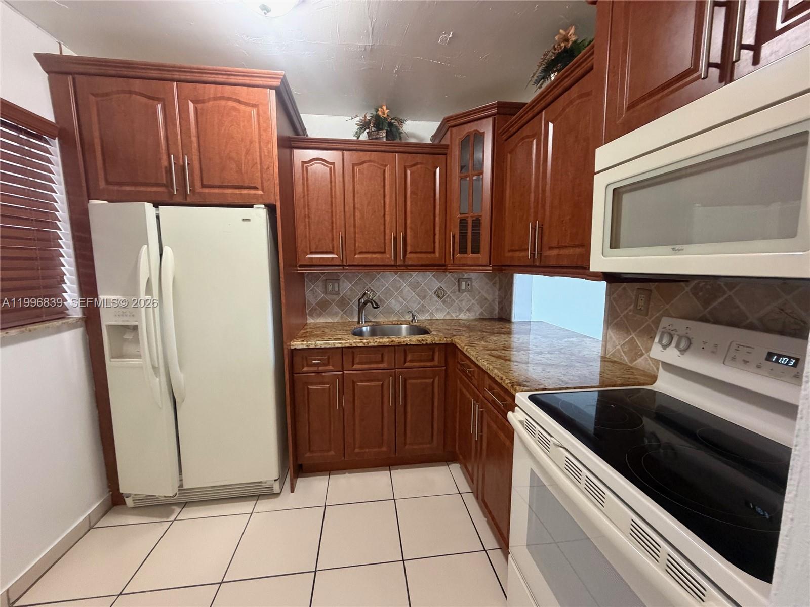 120 Royal Palm Road, Unit 301 Hialeah Gardens, FL 33016 - Photo 8 of 32 a kitchen with a refrigerator sink and stove