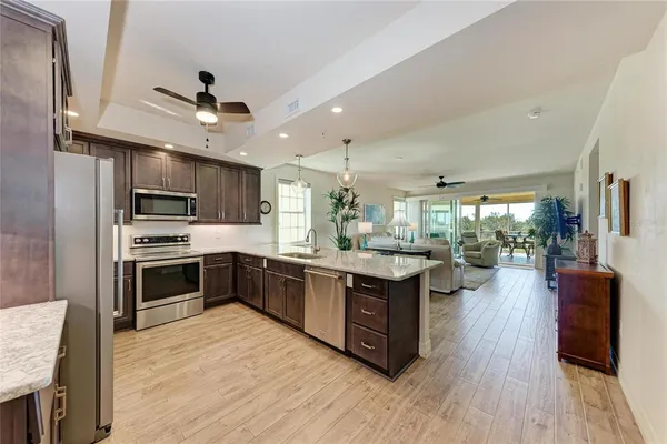 a large kitchen with stainless steel appliances granite countertop a sink stove and refrigerator