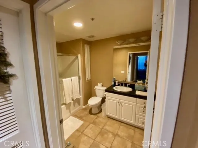 a bathroom with a granite countertop sink a toilet a mirror and vanity