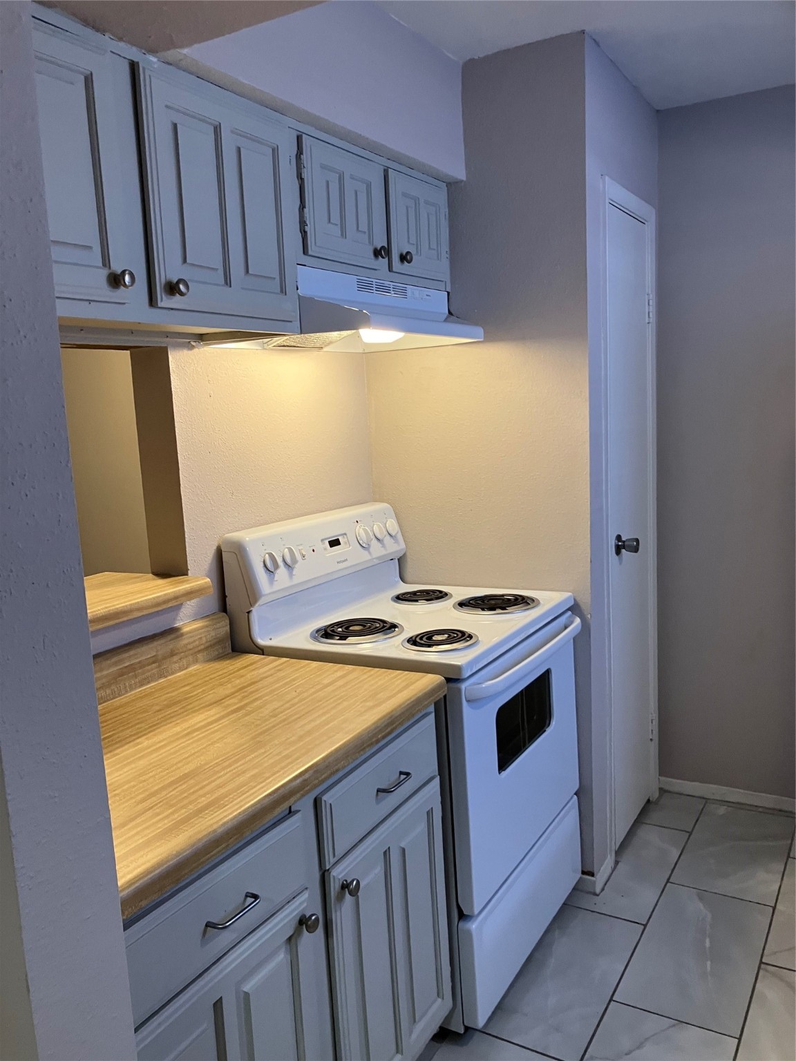 6001 Reims Road, Unit 1406 Houston, TX 77036 - Photo 5 of 13 a kitchen with a stove and a microwave