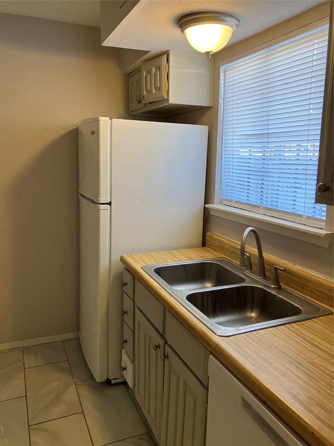 6001 Reims Road, Unit 1406 Houston, TX 77036 - Photo 6 of 13 a kitchen with a sink and a refrigerator