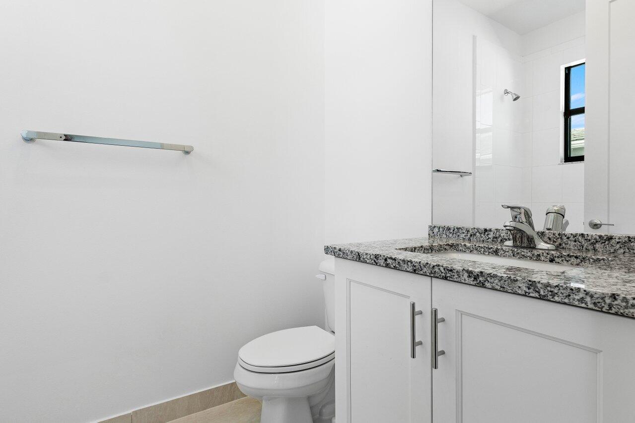 17056 Teton River Road Boca Raton, FL 33496 - Photo 28 of 76 a bathroom with a granite countertop sink and toilet