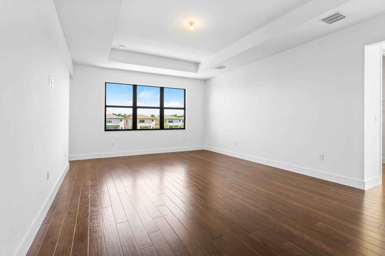 17056 Teton River Road Boca Raton, FL 33496 - Photo 29 of 76 an empty room with wooden floor and windows