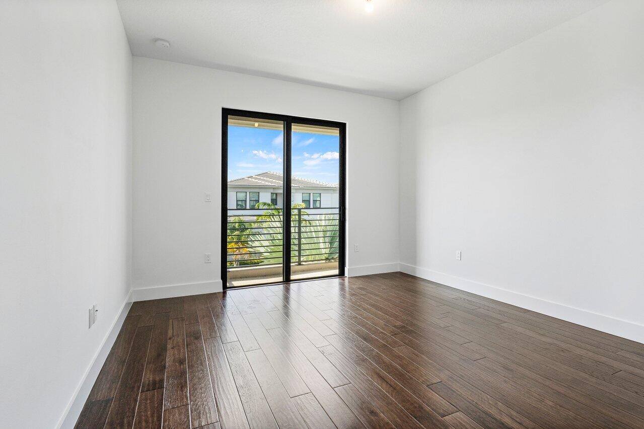 17056 Teton River Road Boca Raton, FL 33496 - Photo 39 of 76 an empty room with wooden floor and windows