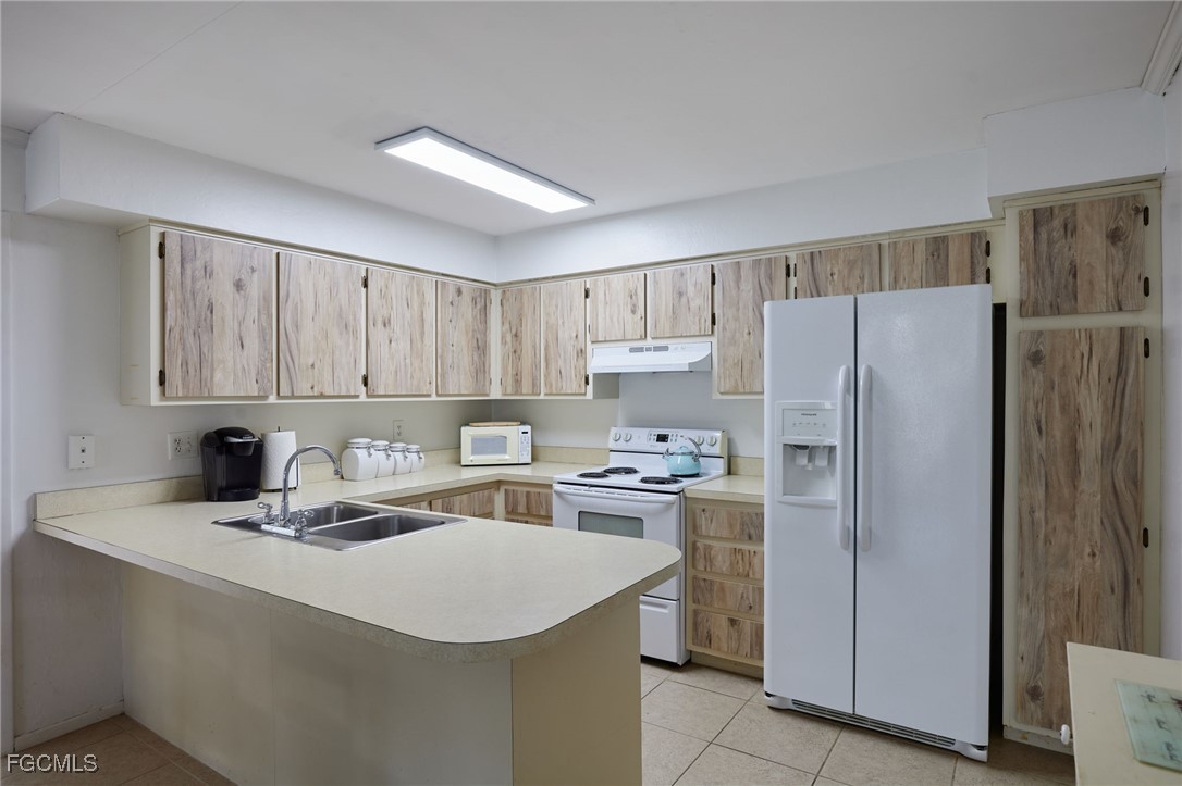 1100 Pondella Road, Unit 916 Cape Coral, FL 33909 - Photo 12 of 26 a kitchen with stainless steel appliances a refrigerator sink and white cabinets