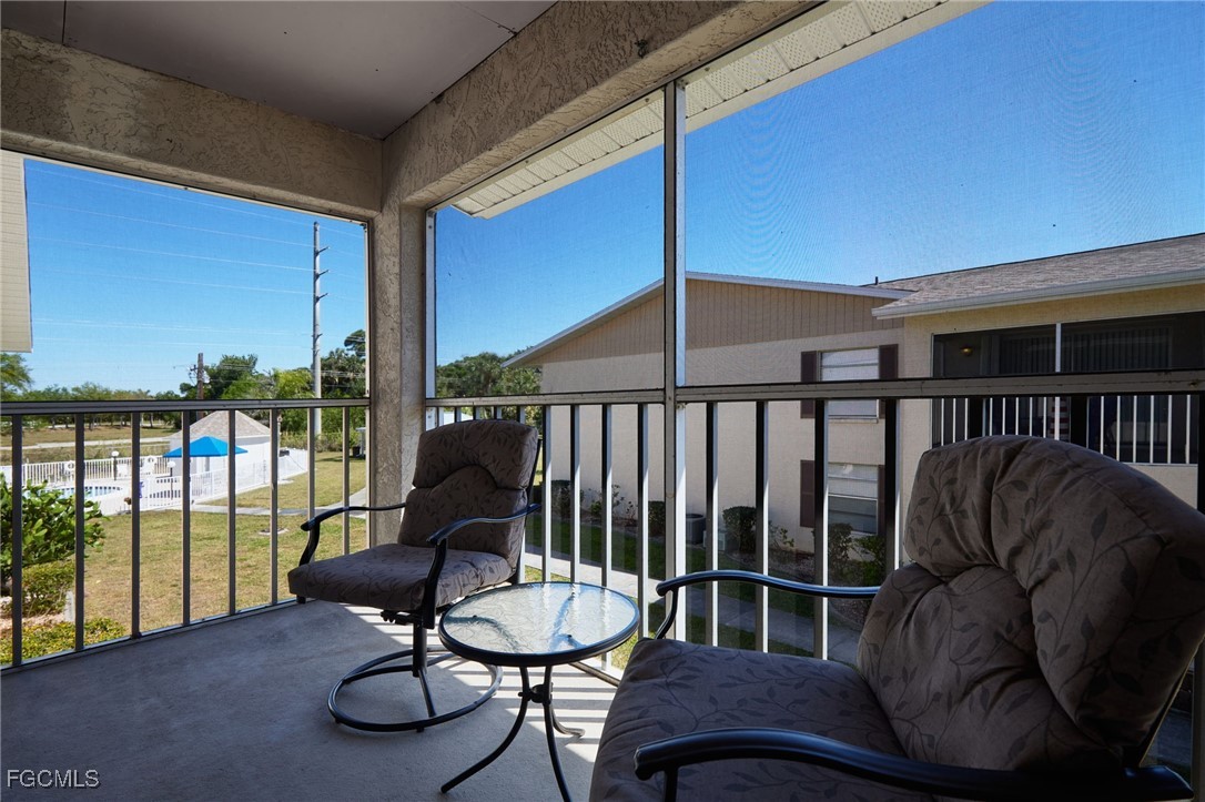 1100 Pondella Road, Unit 916 Cape Coral, FL 33909 - Photo 16 of 26 a balcony with table and chairs