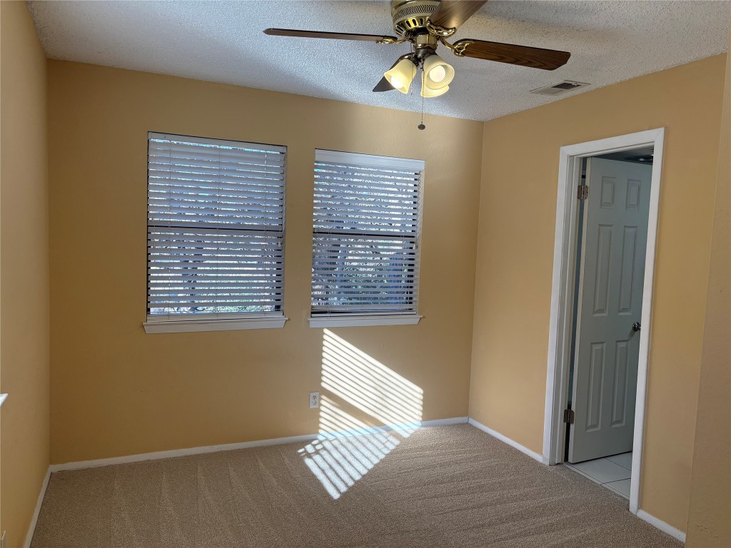 9226 Jollyville Road, Unit 144 Austin, TX 78759 - Photo 14 of 40 Empty room featuring light colored carpet, ceiling fan, and a textured ceiling
