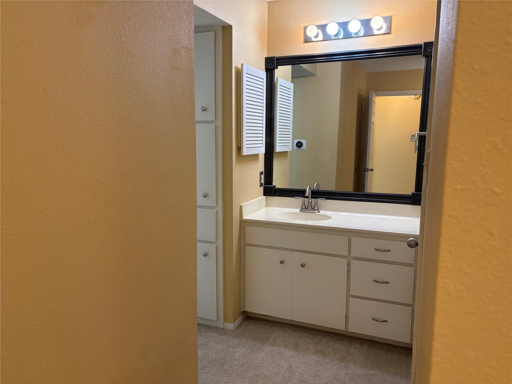 9226 Jollyville Road, Unit 144 Austin, TX 78759 - Photo 21 of 40 Bathroom with a textured wall, vanity, and extra cabinets for storage