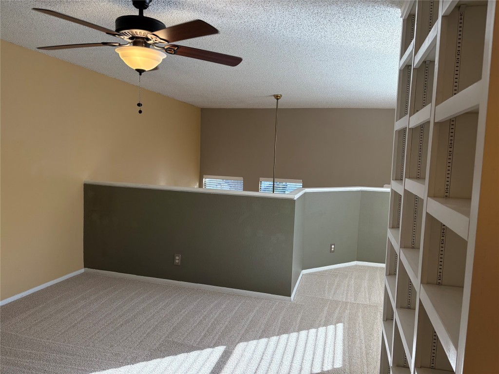 9226 Jollyville Road, Unit 144 Austin, TX 78759 - Photo 24 of 40 Unfurnished flex room with ceiling fan, a textured ceiling, and carpet - could be a second open bedroom