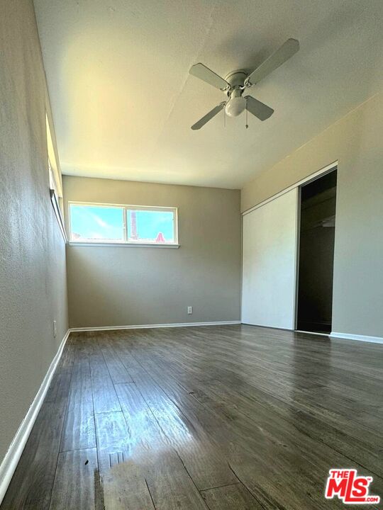 44720 Rodin Avenue Lancaster, CA 93535 - Photo 13 of 18 an empty room with wooden floor fan and windows