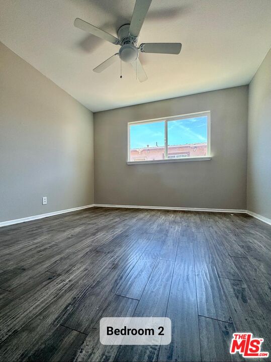44720 Rodin Avenue Lancaster, CA 93535 - Photo 10 of 18 an empty room with wooden floor and windows