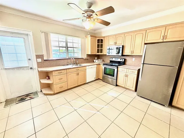 a kitchen with stainless steel appliances granite countertop a refrigerator sink and stove