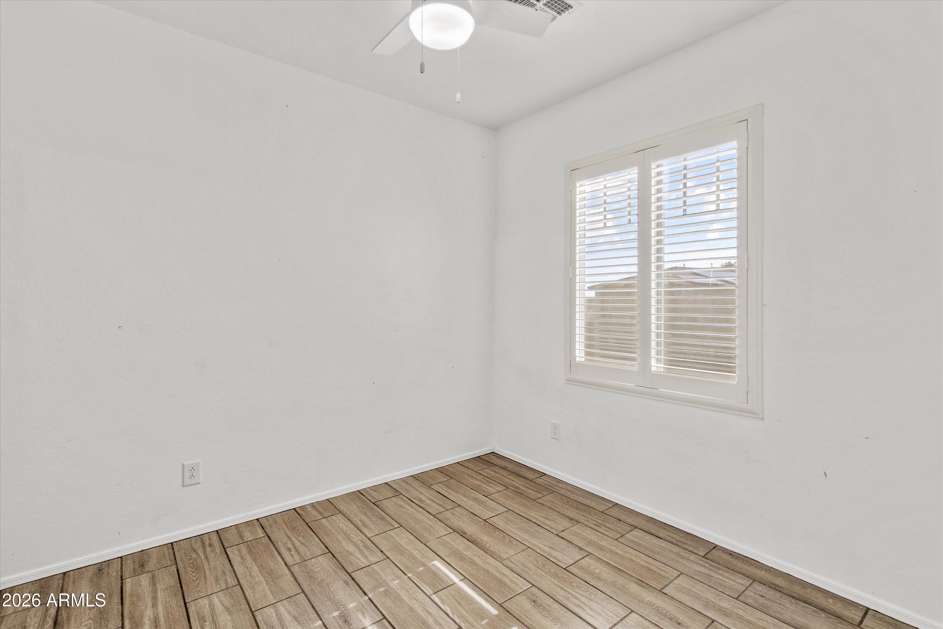 16510 West Tether Trail Surprise, AZ 85387 - Photo 13 of 47 an empty room with wooden floor and windows