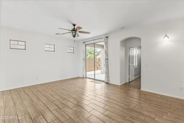 a view of empty room with a window and wooden floor