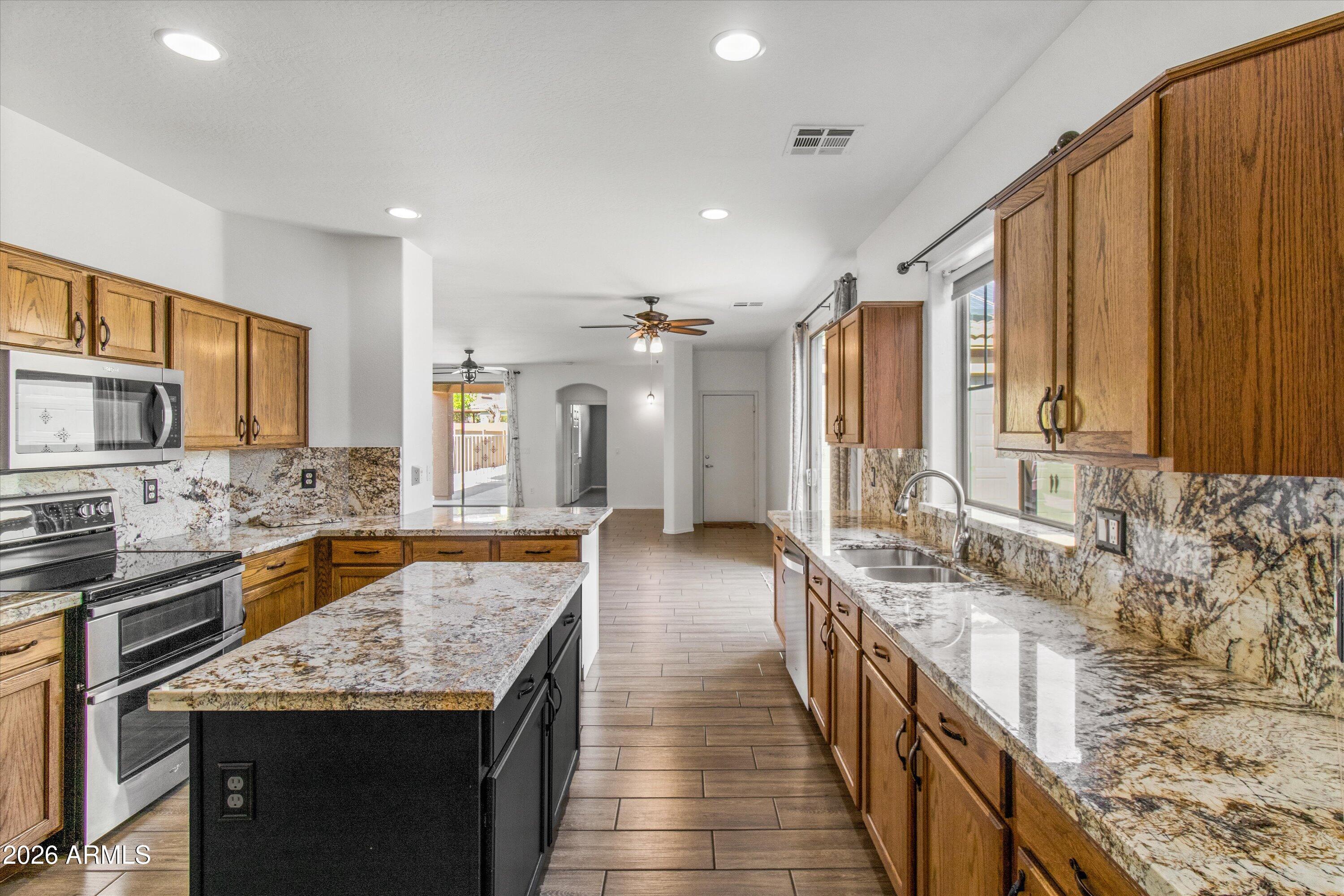 16510 West Tether Trail Surprise, AZ 85387 - Photo 18 of 47 a bathroom with a granite countertop sink a large mirror and a shower