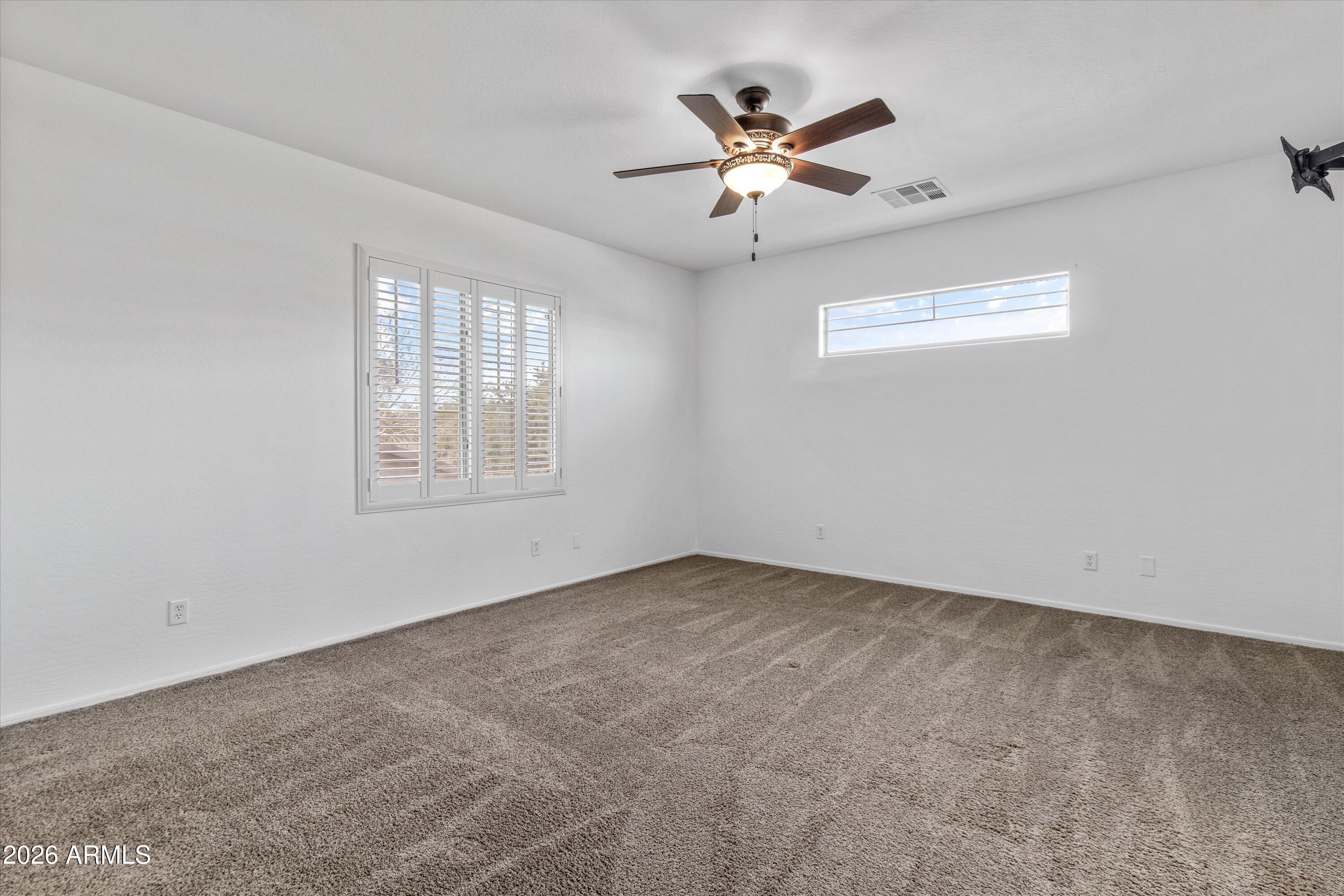 16510 West Tether Trail Surprise, AZ 85387 - Photo 20 of 47 an empty room with windows and ceiling fan