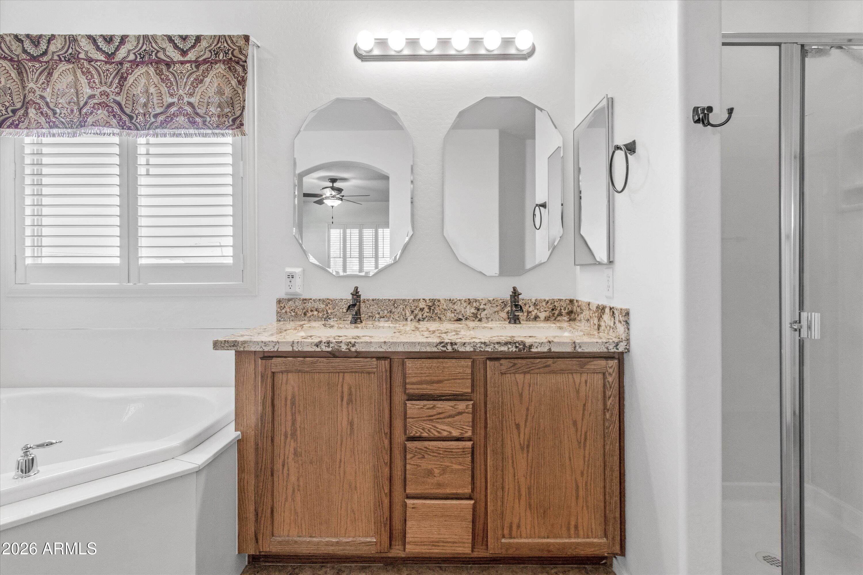 16510 West Tether Trail Surprise, AZ 85387 - Photo 26 of 47 a bathroom with a granite countertop sink and a mirror