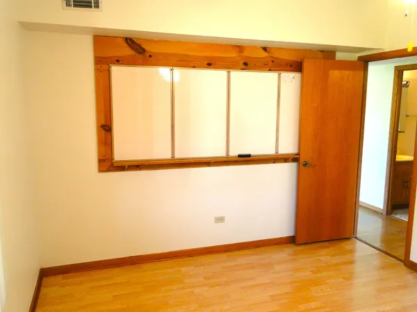 a view of a room with wooden floor and a window