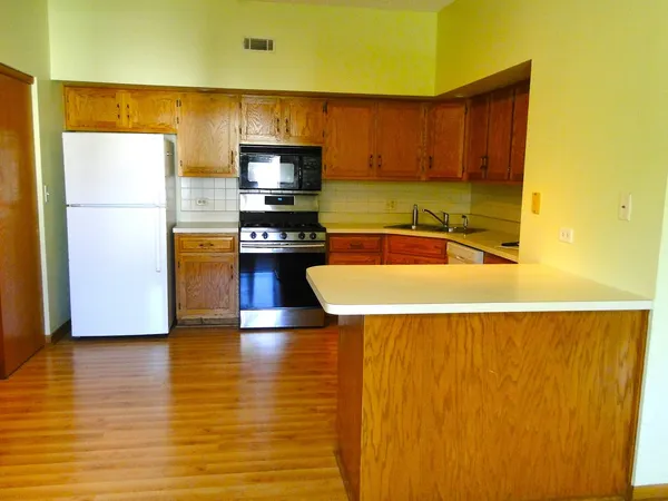 a kitchen with stainless steel appliances a refrigerator a stove top oven a sink and dishwasher