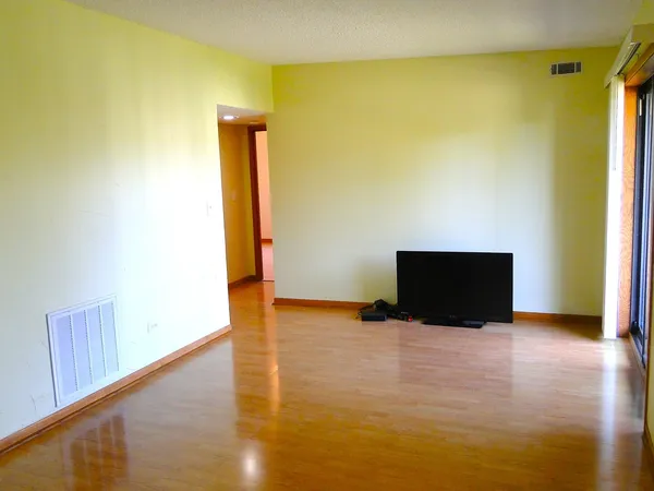 a view of an empty room with wooden floor