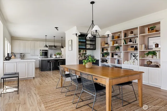 a view of a dining room and livingroom with furniture wooden floor and a chandelier