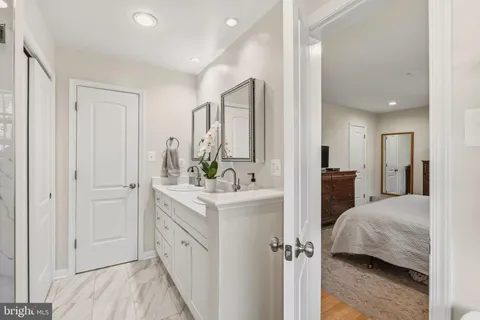 a bathroom with a granite countertop sink toilet and mirror