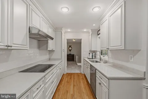 a dining room with furniture a chandelier and wooden floor