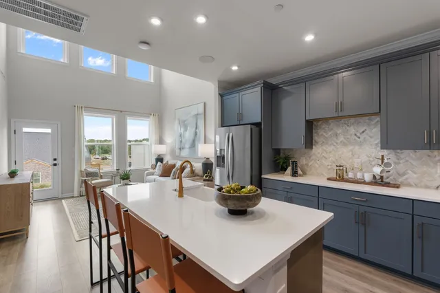 a kitchen with sink a refrigerator and chairs