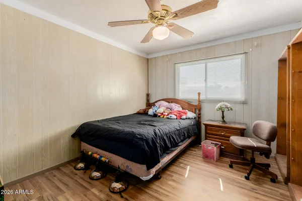 a bedroom with a bed and wooden floor