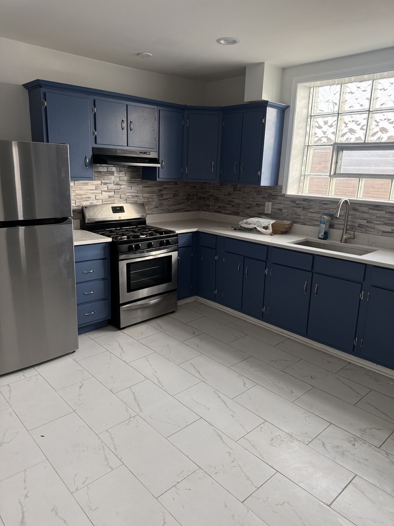 8204 South Elizabeth Street, Unit 2 Chicago, IL 60620 - Photo 10 of 11 a kitchen with stainless steel appliances granite countertop a refrigerator sink and stove
