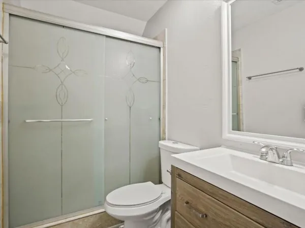 a bathroom with a sink a toilet and shower