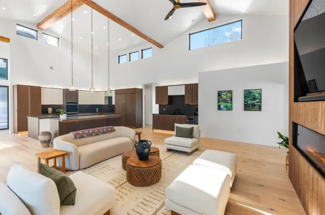 a living room with furniture kitchen view and a flat screen tv