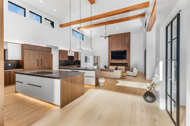 a living room with stainless steel appliances kitchen island granite countertop furniture and a flat screen tv