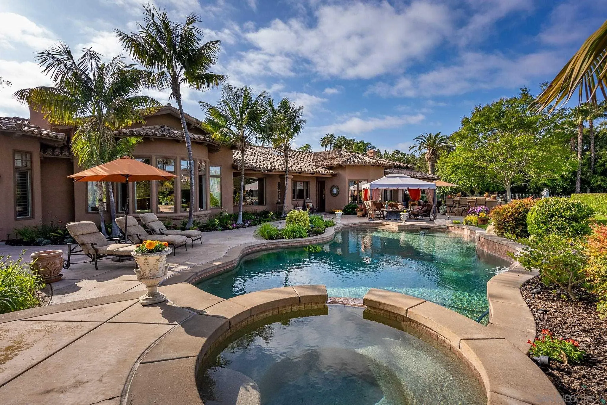 14725 Rancho Santa Fe Farms Road Rancho Santa Fe, CA 92067 - Photo 32 of 50 a view of a swimming pool with lawn chairs under an umbrella